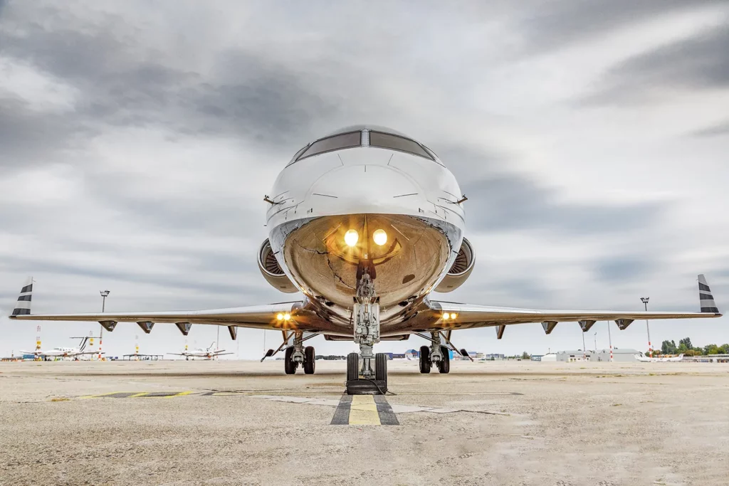 Front view of a jet parked on the tarmac with its landing gear extended, ready for pre-flight inspection, illustrating the importance of maintenance in streamlining aviation.